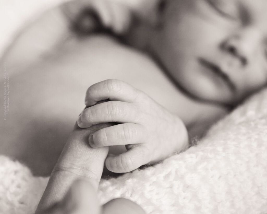 One of Tracy and Gordon's newborn twin boys holding my finger Baby photography: one of Tracy and Gordon's newborn twin boys holding my finger
