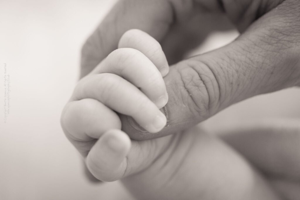 Baby Ruby holding Leona's finger Baby Ruby holding Leona's finger (black & white) / © Copyright 2011 Barrie Spence. All rights reserved.